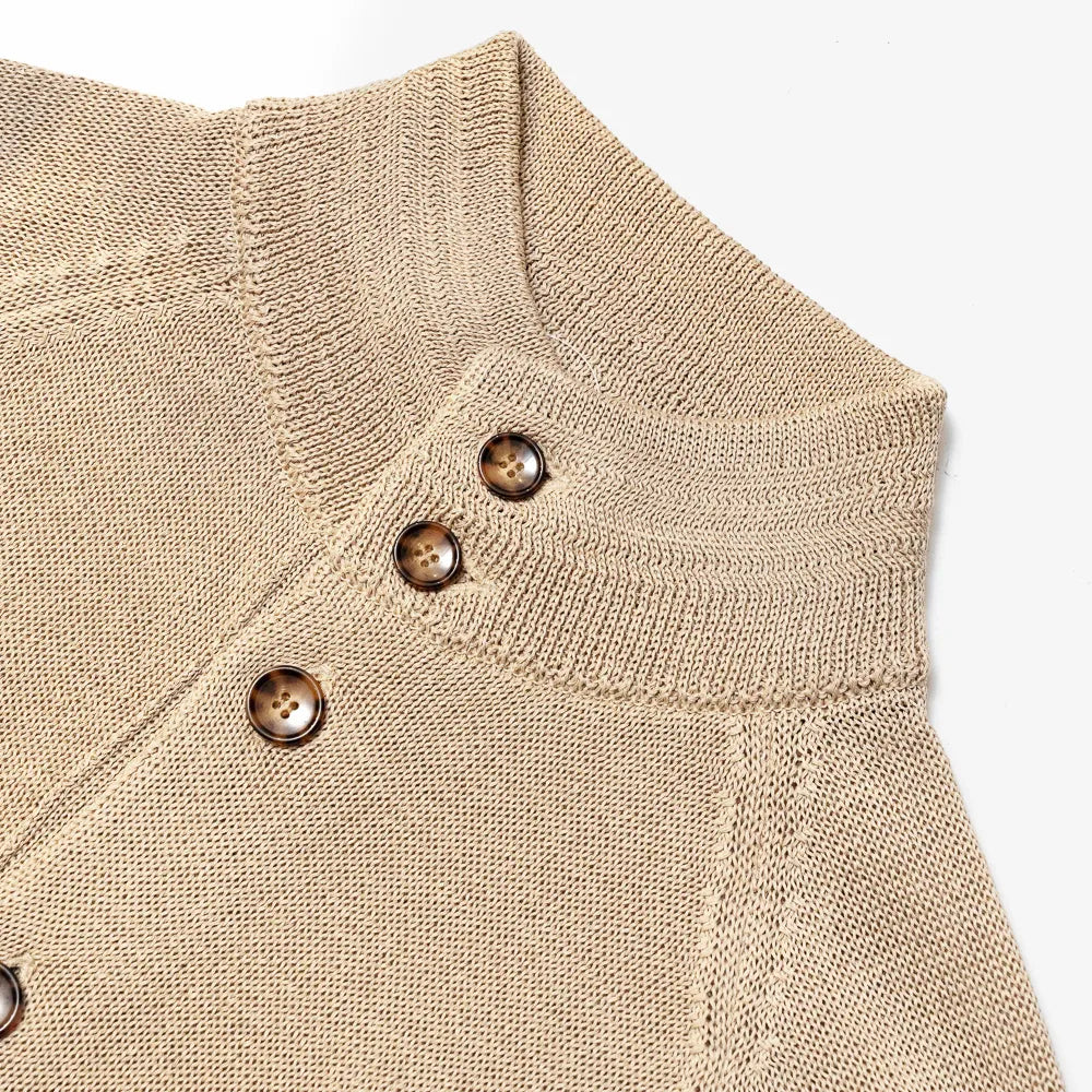 Close-up of the collar closure showing knit texture and refined finishing.
