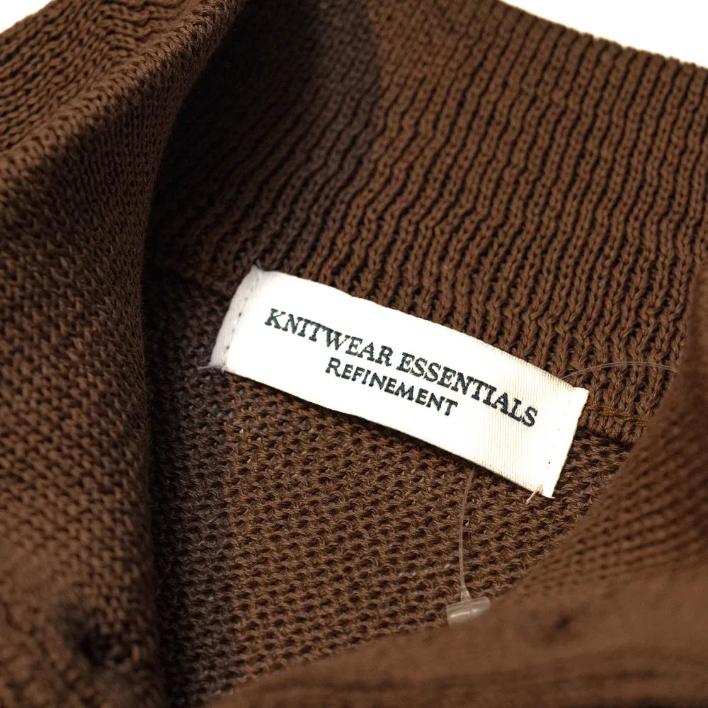 Close-up of the interior label showing “Knitwear Essentials – Refinement” branding and inner knit construction.