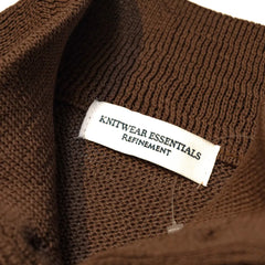 Close-up of the interior label showing “Knitwear Essentials – Refinement” branding and inner knit construction.
