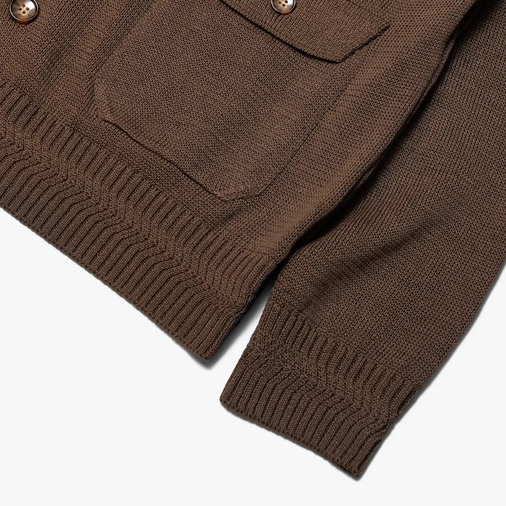 Close-up of the front pocket and cuff showing rib texture, knit stitching, and brown yarn tone.