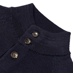 Close-up of the knit bomber collar showing rib-knit structure, button placement, and refined navy yarn texture.