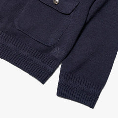 Close-up of the pocket and cuff showing rib texture, knit finishing, and deep navy yarn tone.