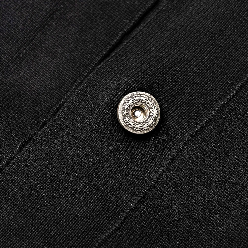 Close-up of the button closure showing hardware detail, matte finish, and placket construction.