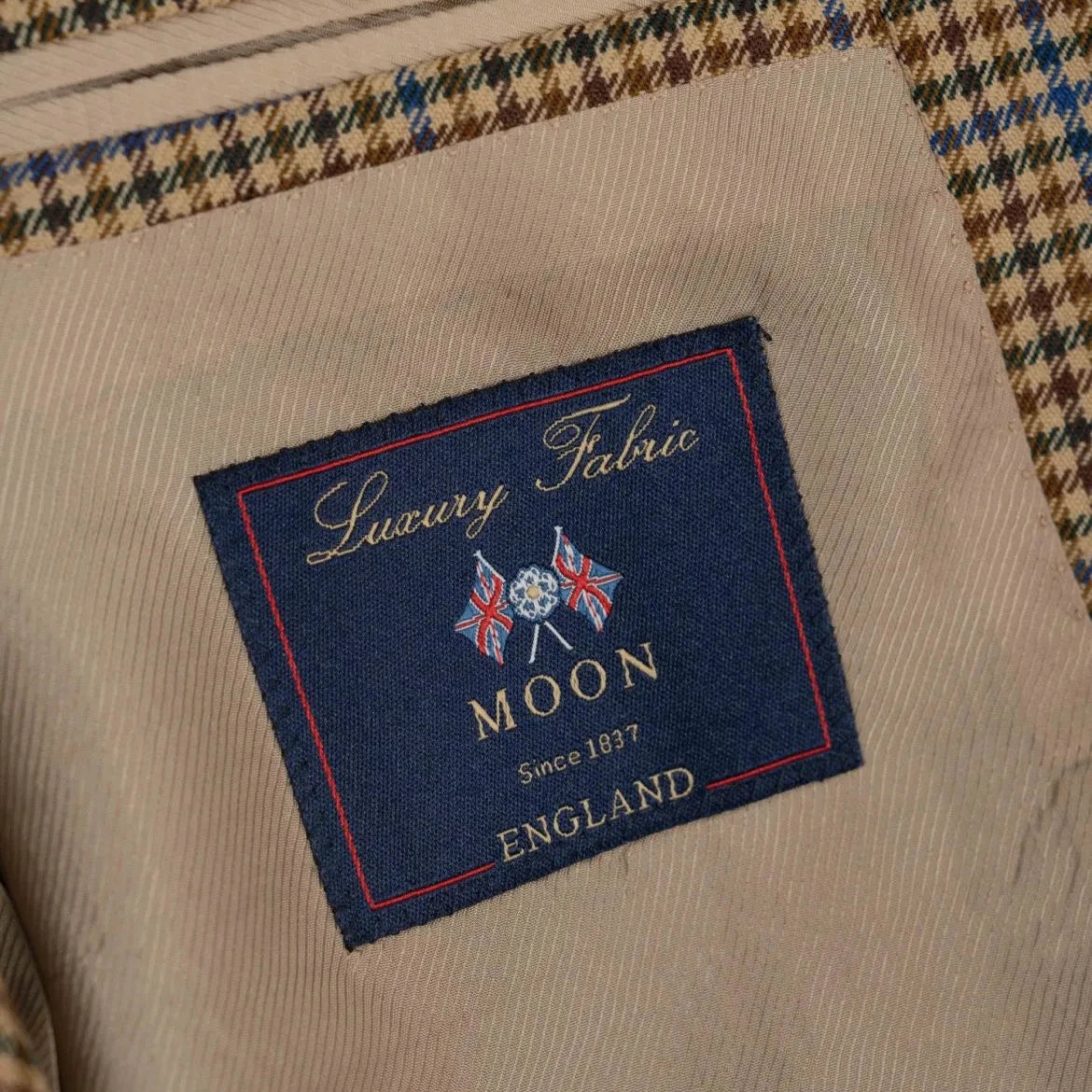 Close-up of the interior label on the RMJ-03 Gunclub Windowpane Jacket showing Refinement Made By Ring Jacket branding and inner lining construction.