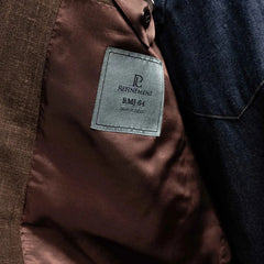 Close-up of the interior label on the RMJ-04 Dark Brown Jacket showing Refinement Made By Ring Jacket branding and lining construction.