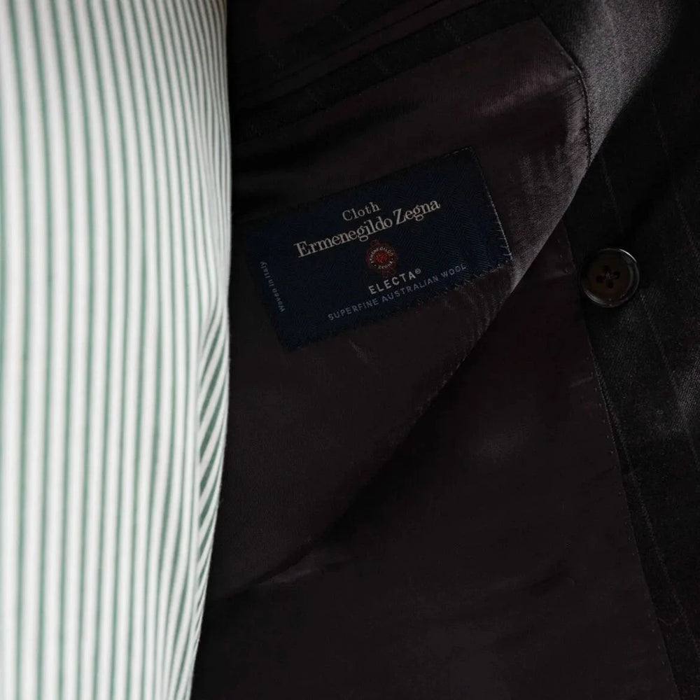 Close-up of the interior labels on the RMJ-04 Chalk Stripe Charcoal Grey Suit showing Refinement Made By Ring Jacket branding and Ermenegildo Zegna Electa fabric label.