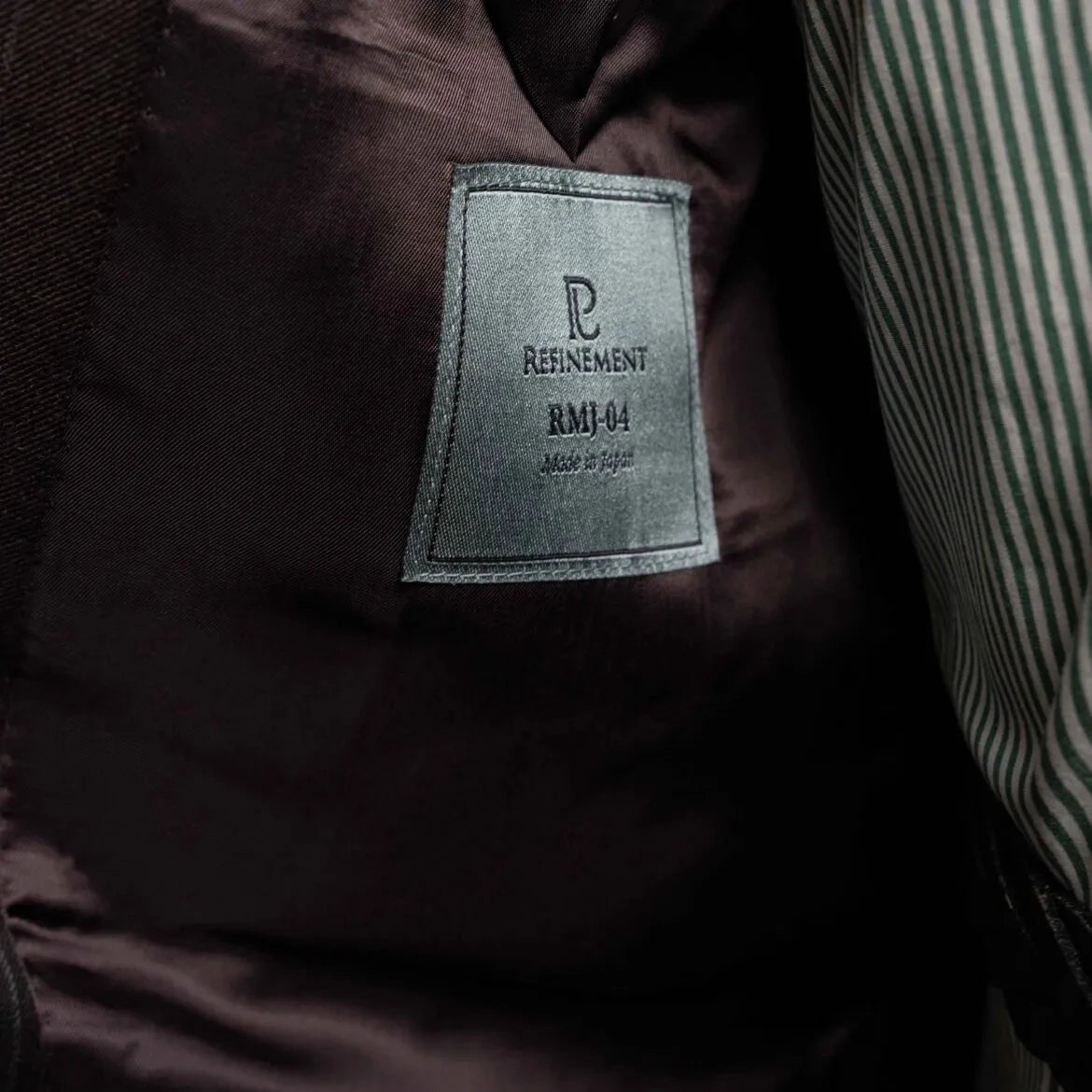 Close-up of the interior labels showing Refinement Made By Ring Jacket branding and the Ermenegildo Zegna Electa fabric label.
