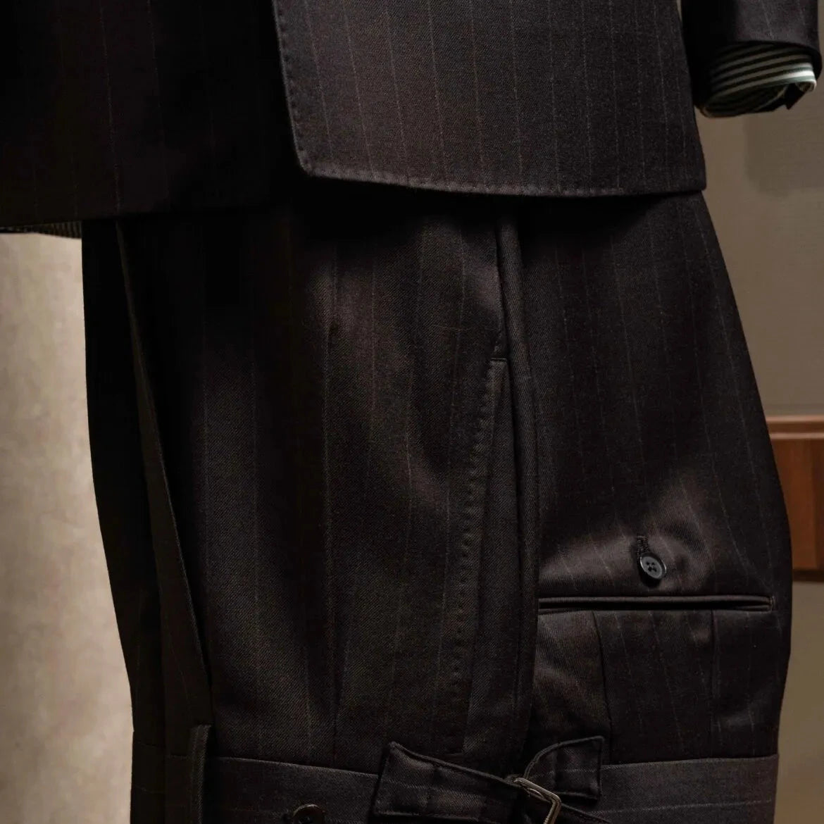 Front view of the trousers from the RMJ-04 Chalk Stripe Dark Brown Suit showing the pleats, clean leg line, and refined dark brown chalk stripe.