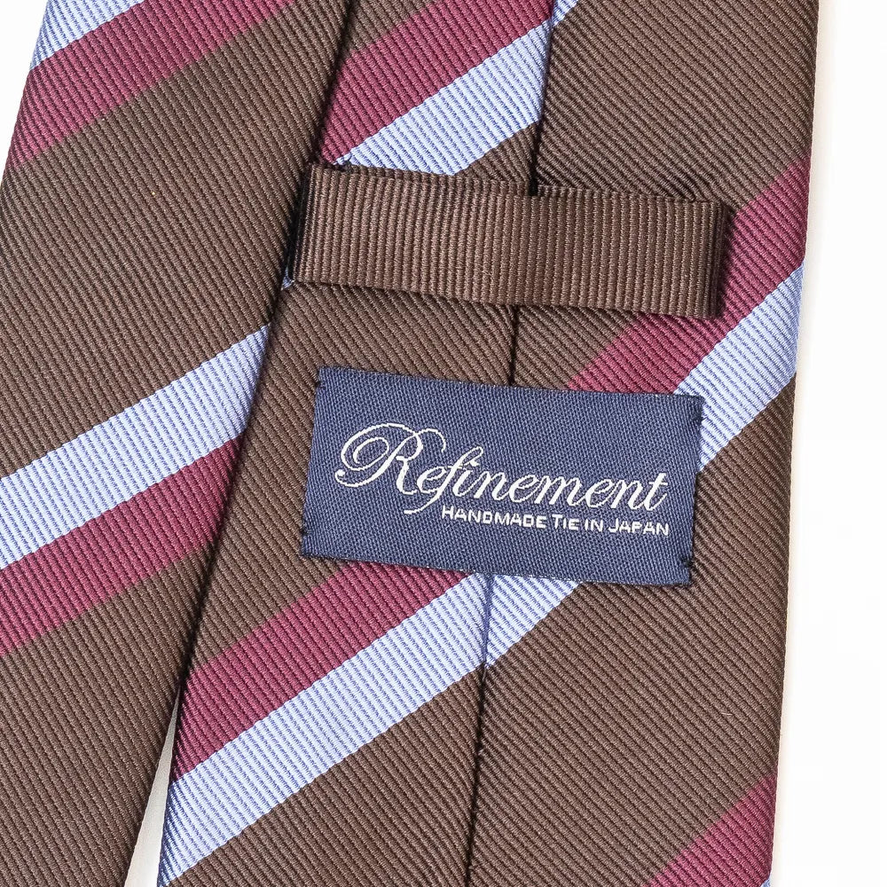Close-up of the Refinement repp stripe neck tie showing the textured repp silk weave and brand label detail.