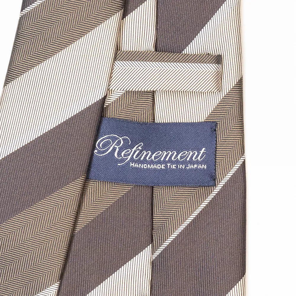 Close-up of the Refinement herringbone stripe neck tie showing textured weave and brand label detail.
