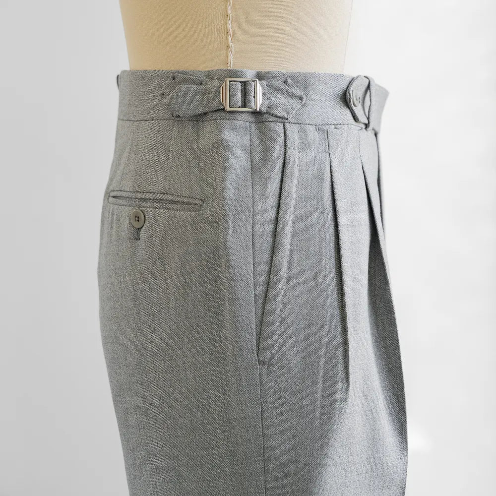 Close-up of the extended waistband tab, button, stitching, and texture of the Airesco fabric.