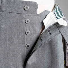 Close-up of the fly showing zipper or button closure, inner placket construction, and stitch accuracy.