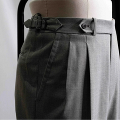 Close-up of the waistband showing button closure, belt loops, stitching precision, and sartorial construction.