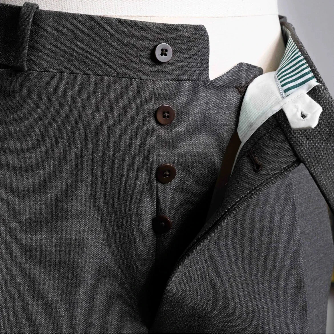 Close-up of the fly showing zipper or button closure, inner placket construction, and stitch accuracy.