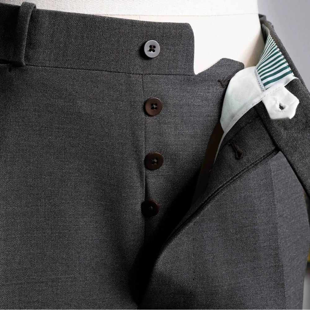 Close-up of the fly showing zipper or button closure, inner placket construction, and stitch accuracy.