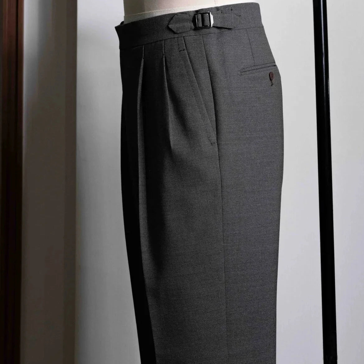 Side view showing the leg shape, side seam, and natural movement of the taupe-brown wool.