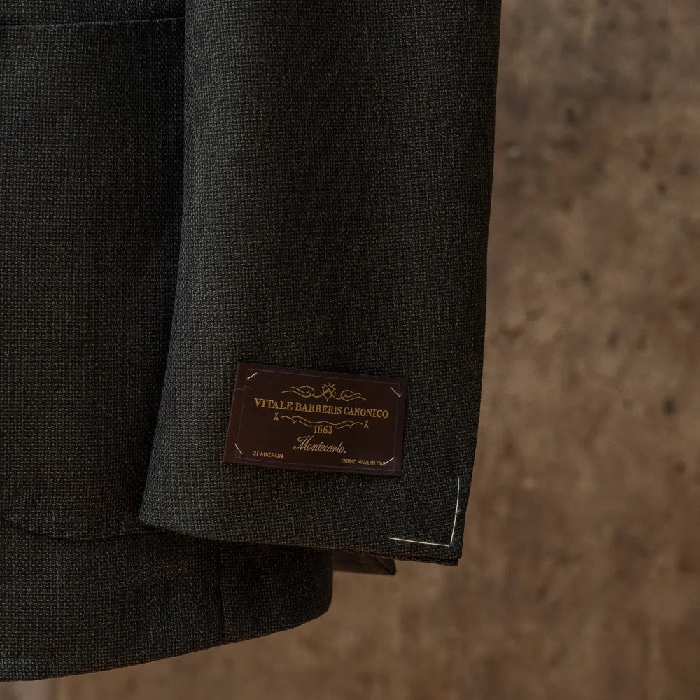 Close-up of the lower hem area showing the Vitale Barberis Canonico label stitched near the hem of the RMJ-03 Jacket Green by VBC.