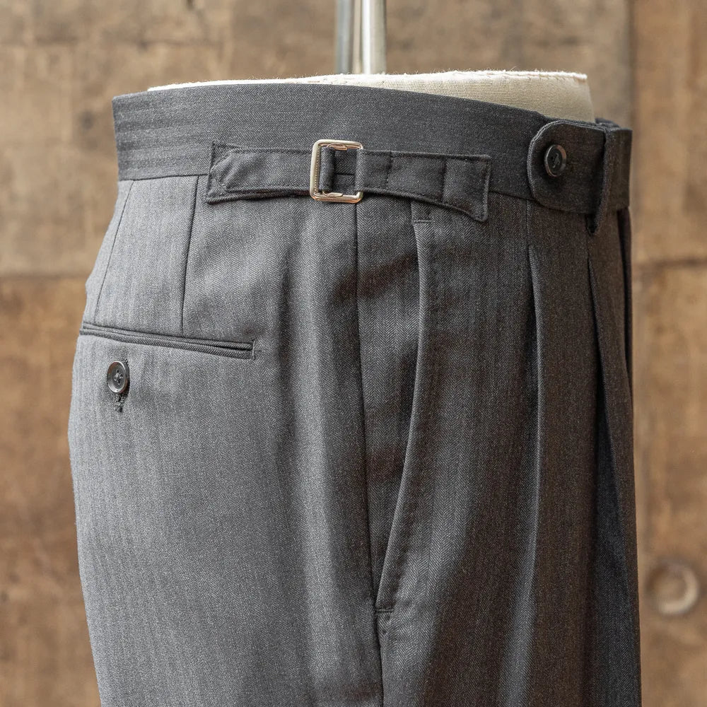 Close-up of the waistband and side adjuster on the RMJ-04 suit trousers showing buckle hardware, stitching, and waist construction.