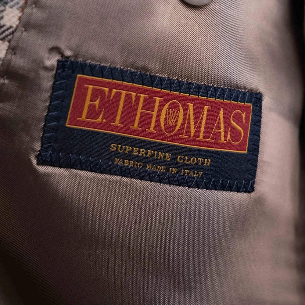 Close-up of the interior label showing Refinement Tailoring branding and E. Thomas cloth identification.