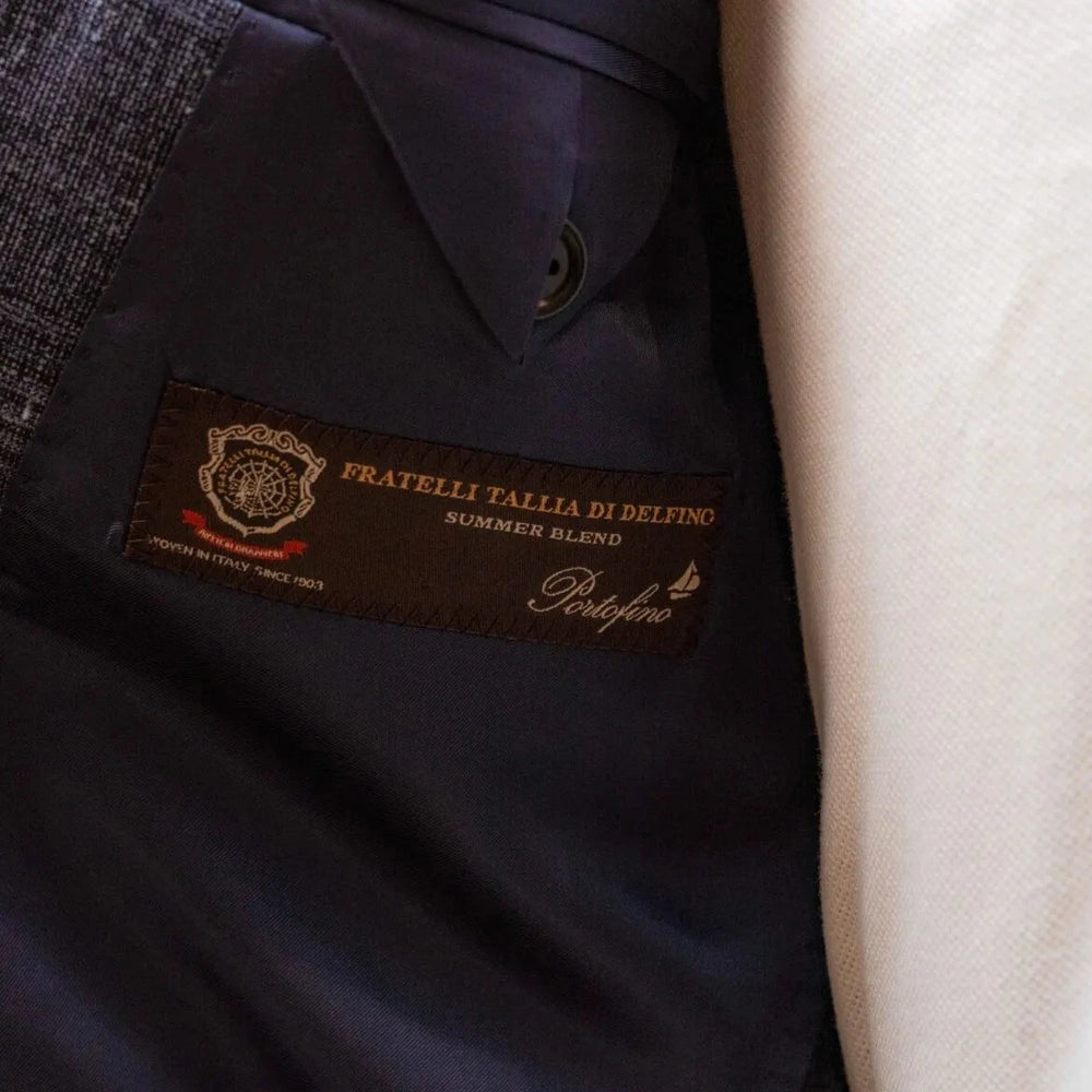 Close-up of the interior label showing Refinement Tailoring branding and Fratelli Tallia di Delfino cloth identification.