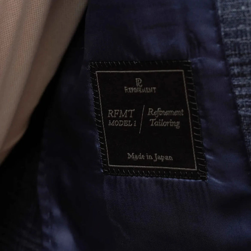 Close-up of the interior label showing Refinement Tailoring branding and Fratelli Tallia di Delfino cloth identification.