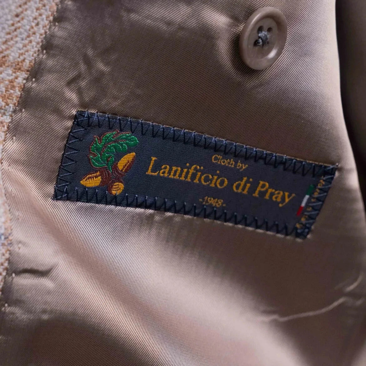 Close-up of the interior label showing Refinement Tailoring branding and Lanificio di Pray fabric marking.