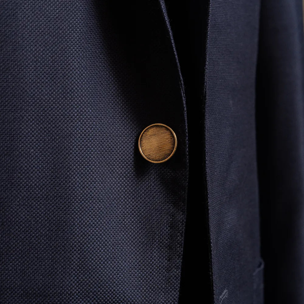 Close-up of the front button highlighting fabric texture and finishing.