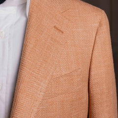 Close-up of the lapel showing notch lapel construction, pick stitching, and the refined salmon herringbone wool from E. Thomas.