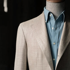Upper body close-up of the Summertime Beige jacket showing lapel roll, chest pocket, and Loro Piana fabric texture.