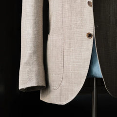Side view showing the sleeve, button stance, and drape of the Loro Piana Summertime beige fabric.