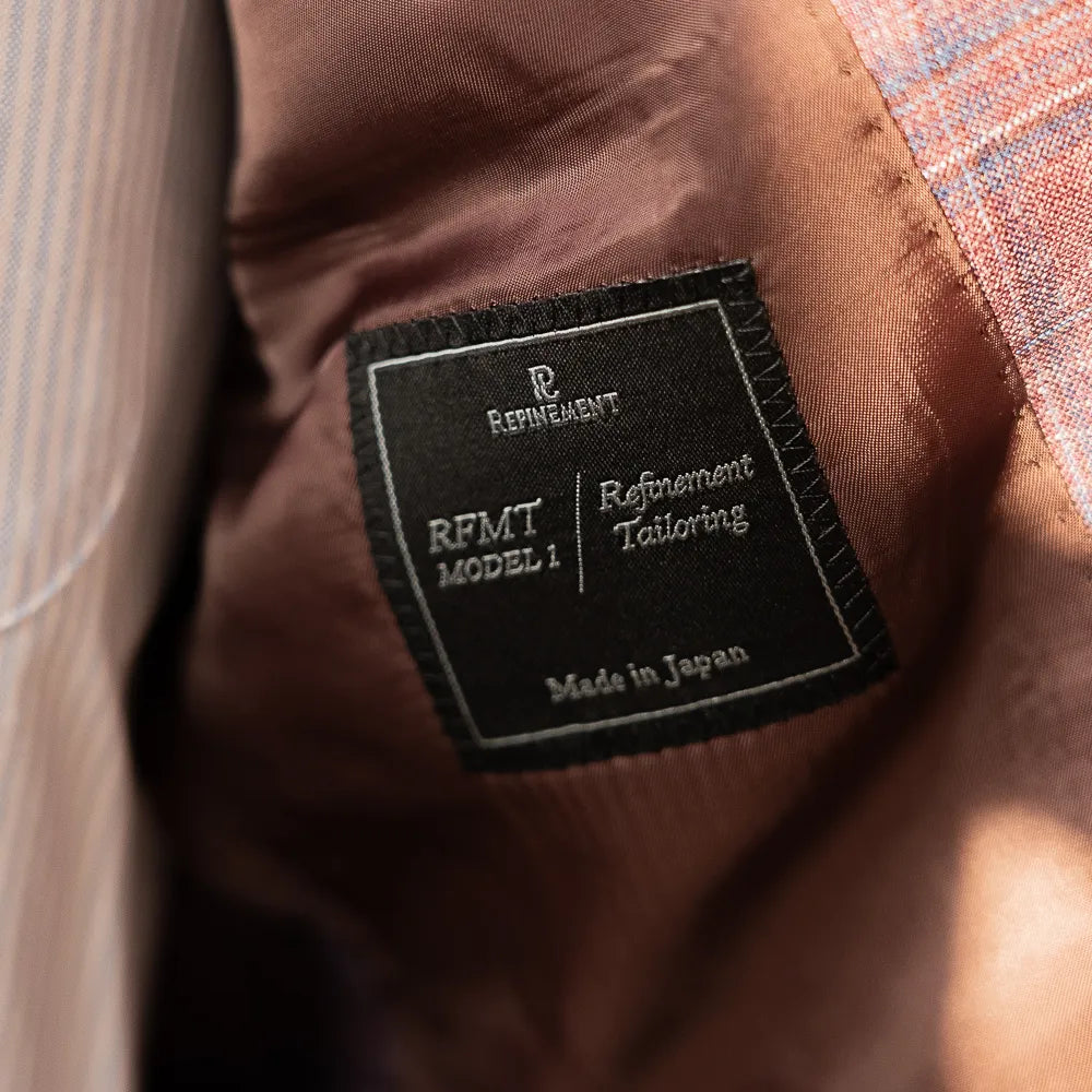 Interior view of the Refinement Tailoring brand label, showing craftsmanship and clean lining work.