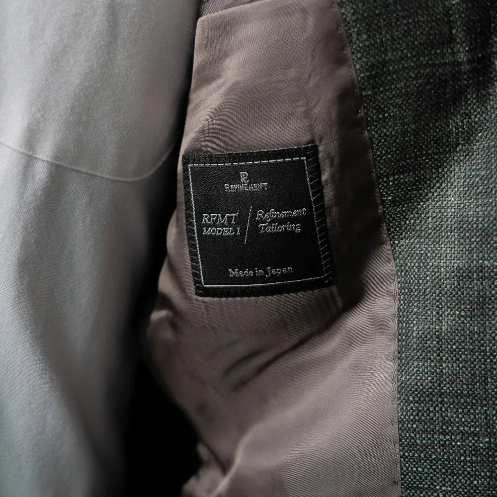 Interior close-up of the Refinement Tailoring brand label showing clean finishing and inner construction.
