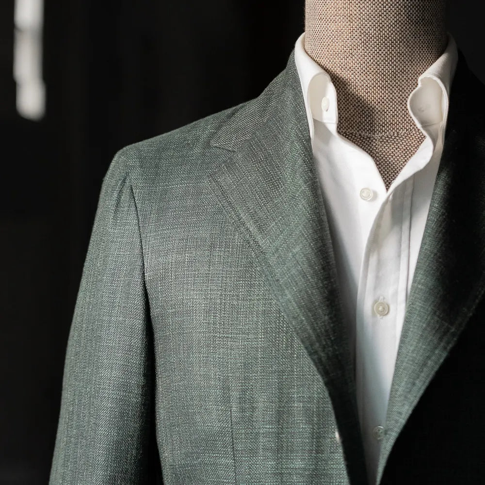 Close-up of the chest area highlighting the lapel roll, welt pocket, and textured green Summertime weave.
