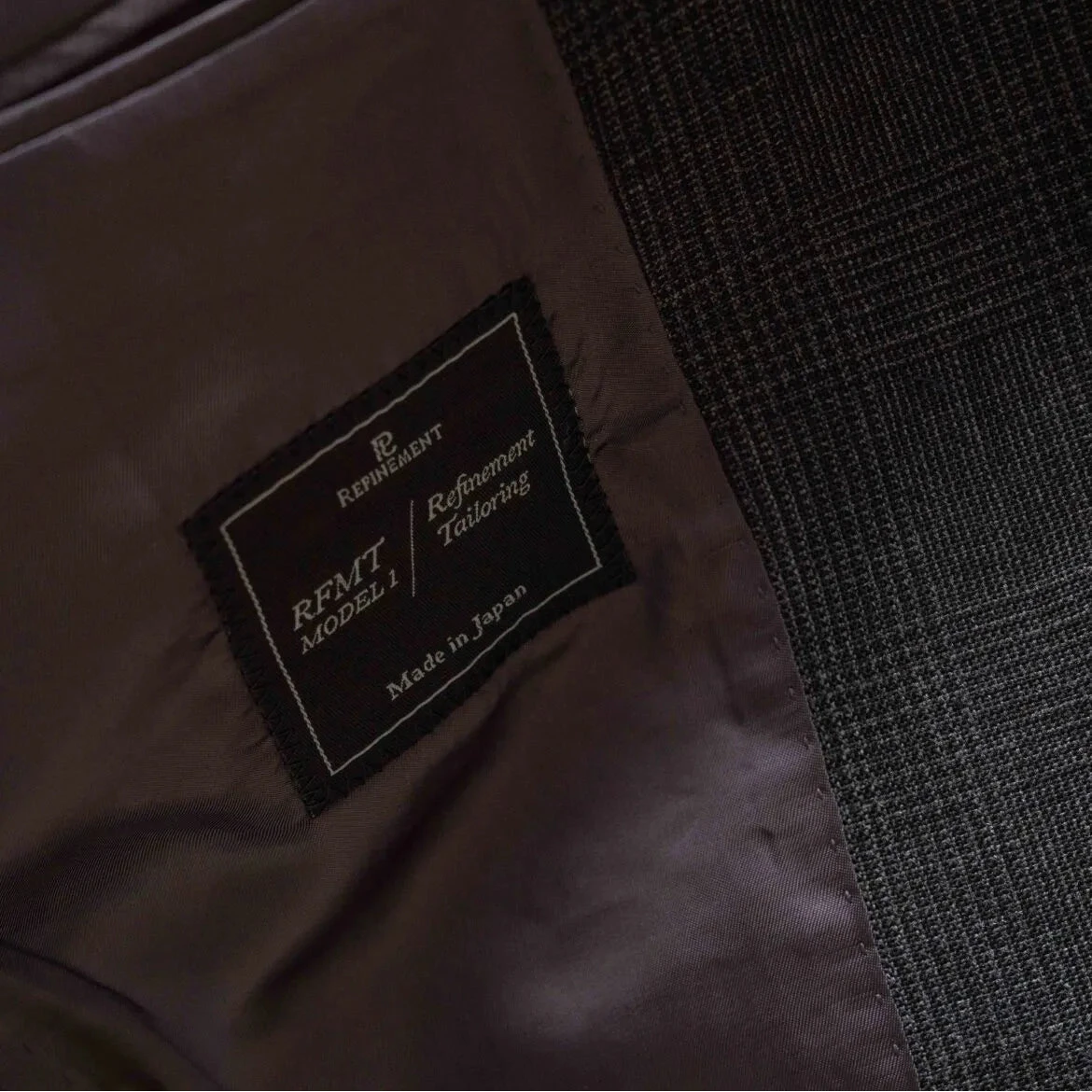 Close-up of the interior label showing Refinement Tailoring branding and Woodhead cloth identification.