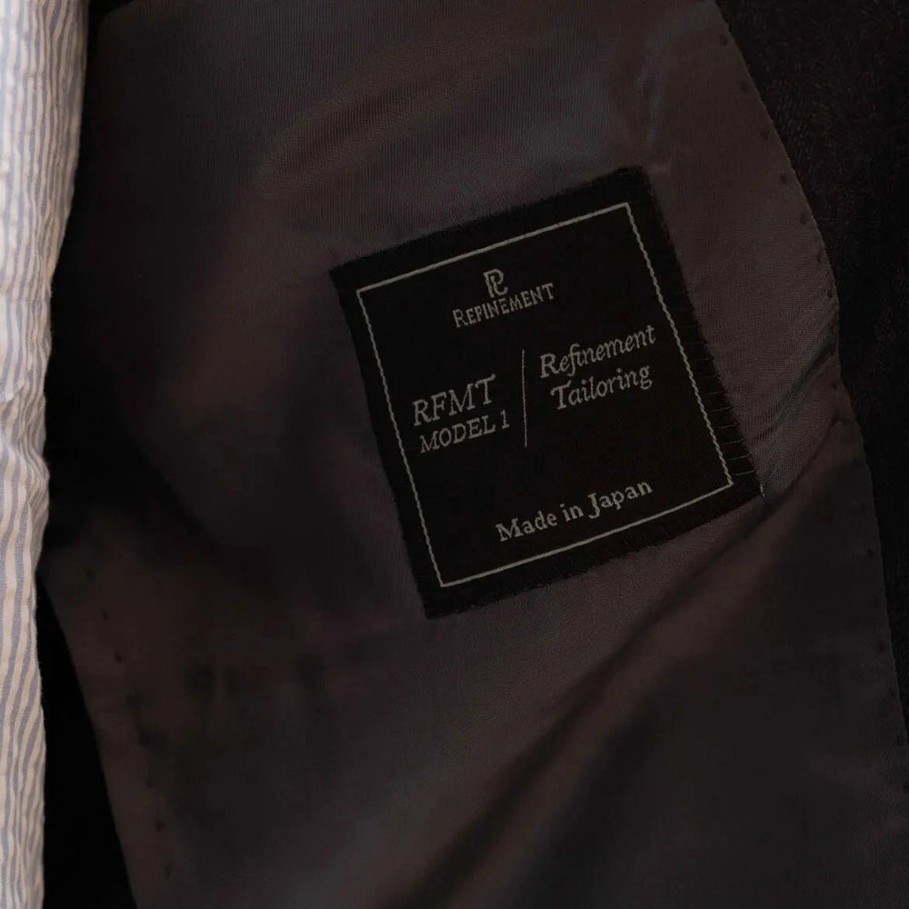 Close-up of the interior label showing Refinement Tailoring branding and Savile Clifford cloth identification.