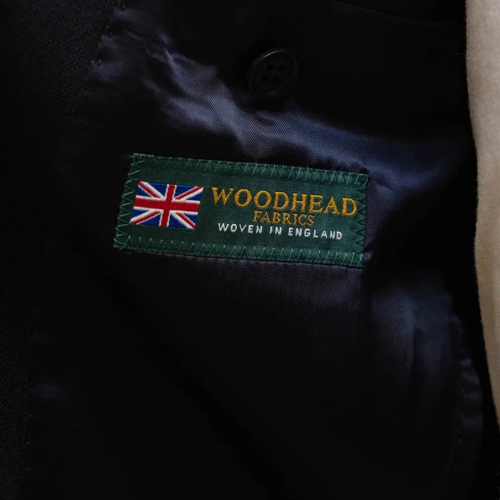 Close-up of the Refinement Tailoring label and Woodhead cloth tag showing craftsmanship.