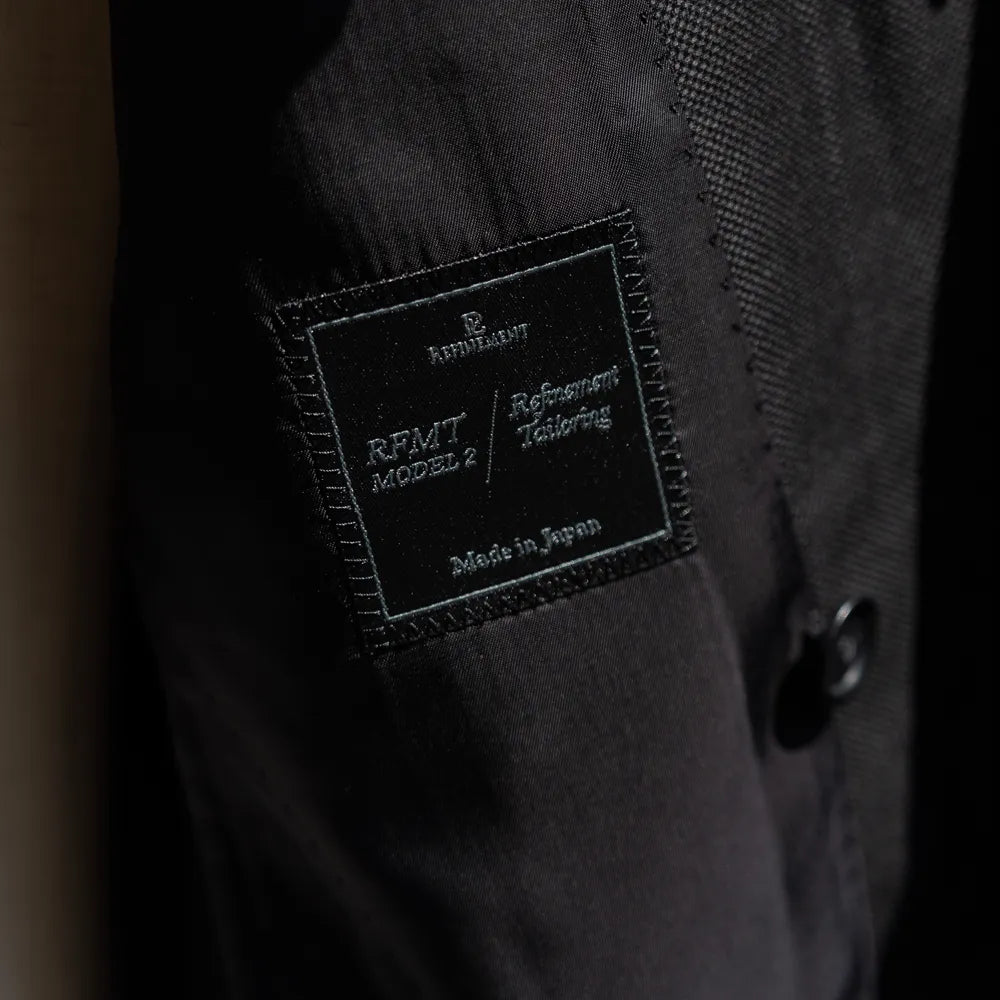 Close-up of the Refinement inner brand label stitched inside the jacket.
