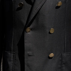 Close-up of the double breasted button configuration showing fabric texture and brass buttons.
