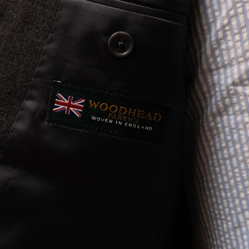 Close-up of the interior label showing Refinement Tailoring branding and Woodhead cloth identification.