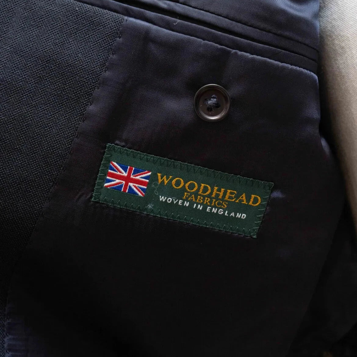 Close-up of the interior trousers label showing Refinement branding and Woodhead cloth marking.