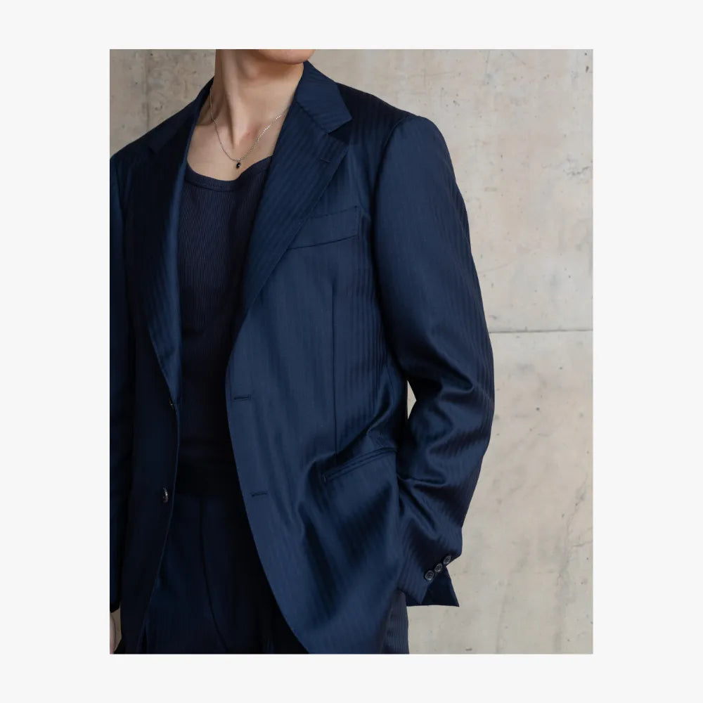 Close-up detail of RMJ-03 navy single breasted herringbone suit by Ring Jacket showing herringbone pattern