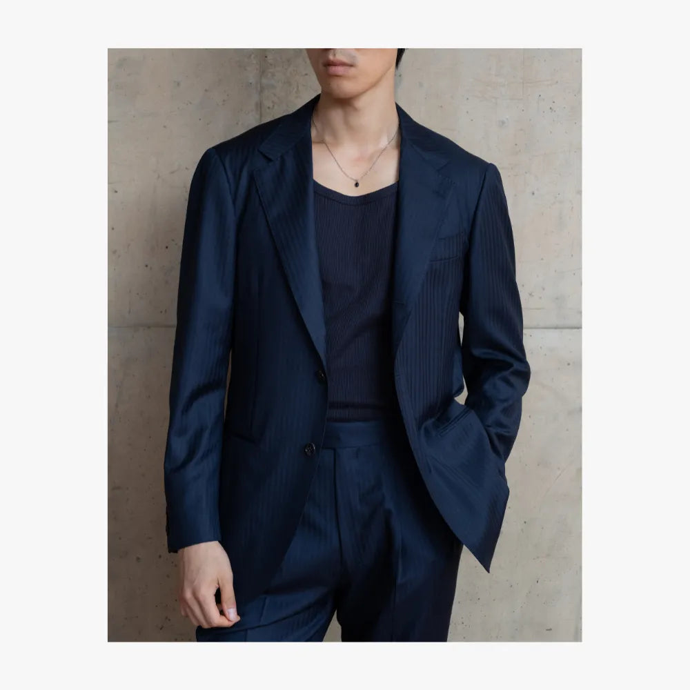 Man wearing RMJ-03 navy single breasted herringbone suit by Ring Jacket styled in a refined tailored look