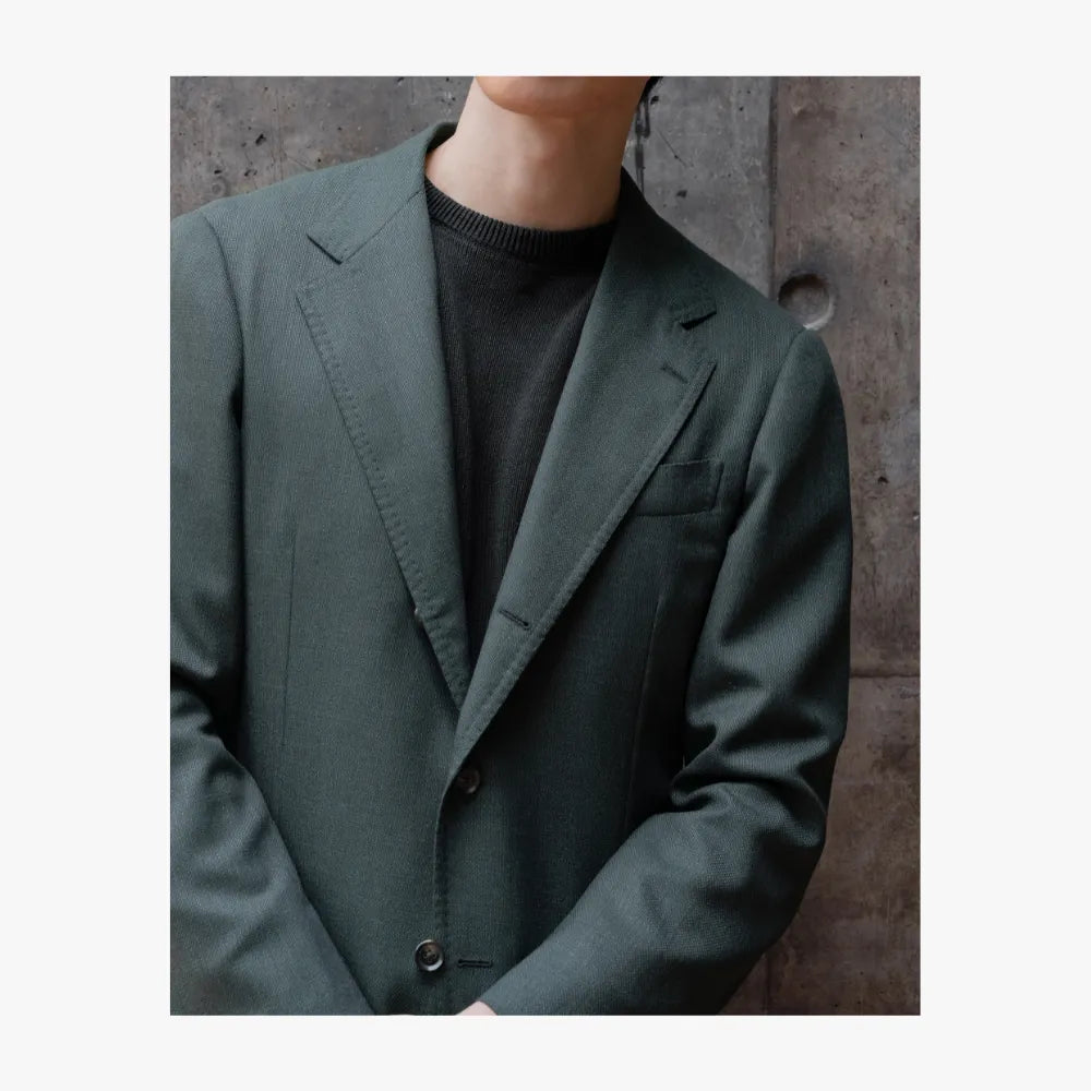 Close-up detail of RMJ-03 green single breasted jacket by Ring Jacket showing VBC fabric texture