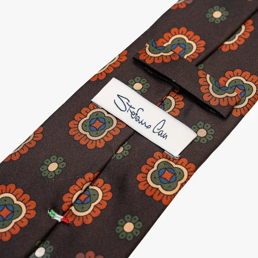 Close-up of the back side of the Stefano Cau floral tie showing the brand label, hand-finished stitching, and clean construction.