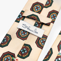 Close-up of the back side of the Stefano Cau floral tie showing the brand label, hand-finished stitching, and clean construction.