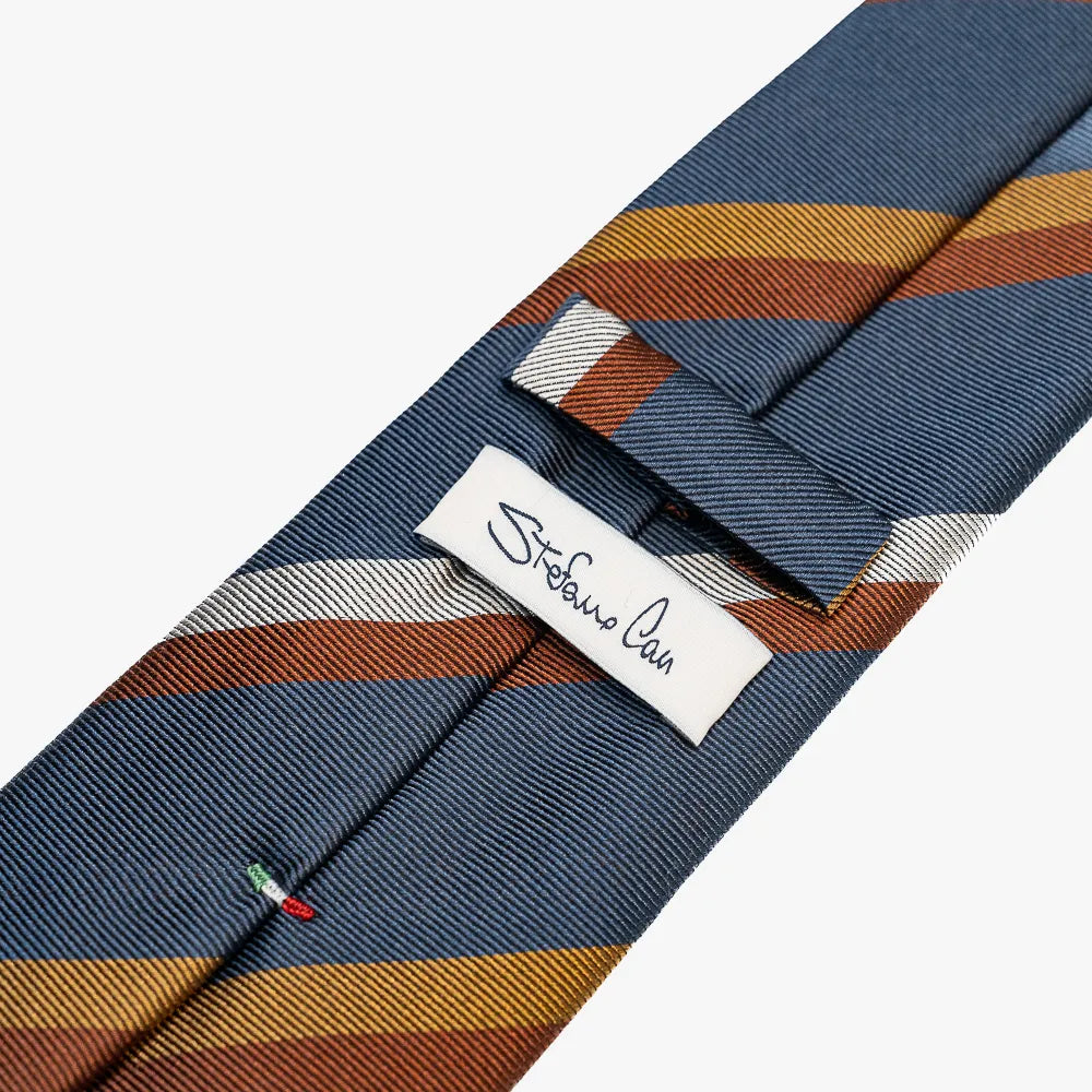 Close-up of the back side of the Stefano Cau regimental tie showing the brand label, hand-finished stitching, and clean construction.