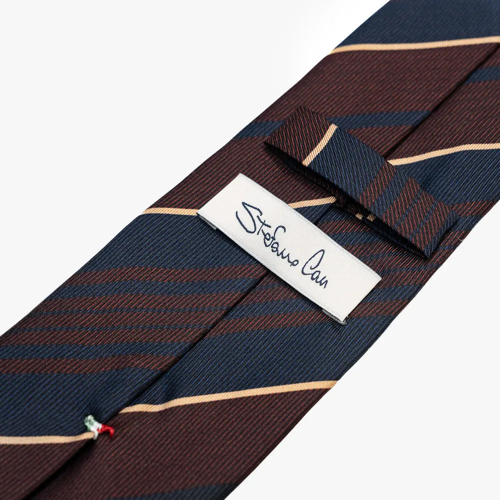 Close-up of the back side of the Stefano Cau regimental tie showing the brand label, hand-finished stitching, and clean construction.