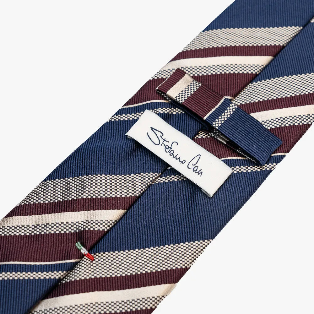 Close-up of the back side of the Stefano Cau regimental tie showing the brand label, hand-finished stitching, and clean construction.