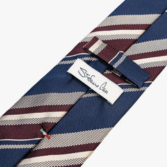 Close-up of the back side of the Stefano Cau regimental tie showing the brand label, hand-finished stitching, and clean construction.