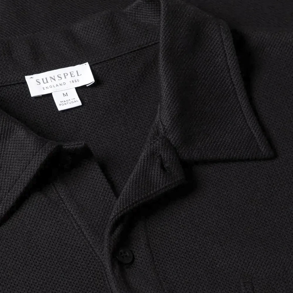 Close-up of the collar of the Sunspel Riviera Polo Shirt Black showing the breathable mesh cotton and refined neckline.